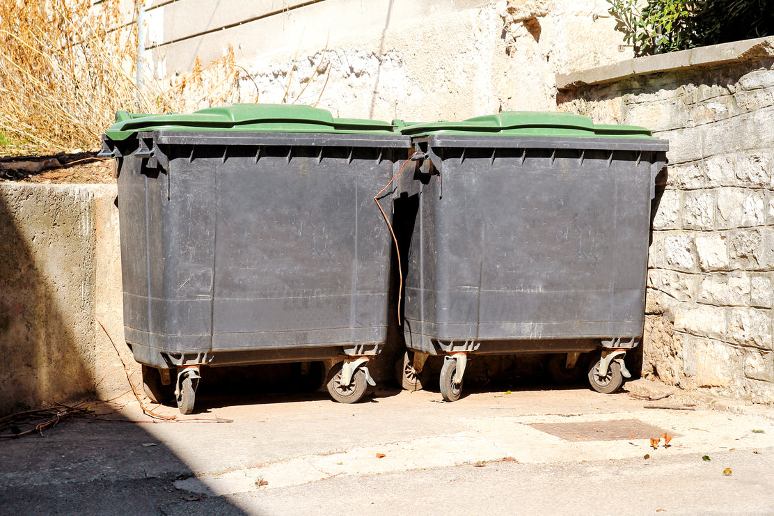 Green big size wheelie bin in a street. Garbage container ready